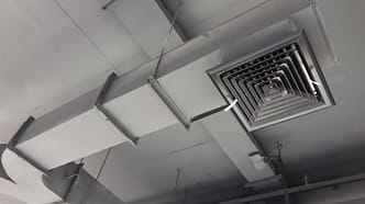 sistema de dutos de ventilação forçada instalado no teto de um ambiente fechado - Curso Laudo Ventilação Cozinhas