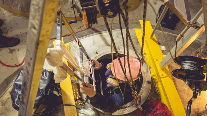 Entrada segura em espaço confinado: Uso adequado de EPIs e sistema de resgate garantem a integridade do trabalhador. - Curso Inventário Espaço Confinado.